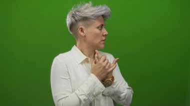 İki eli de yeşil stüdyoda, krem bluz ve açık tahta saat giyen kadın debriyaj sandığı..