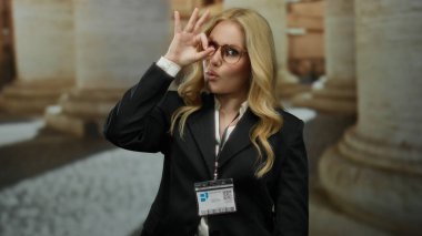 Sarışın, gülümseyen kampüs öğrencisi, siyah gözlüklü, dışarıda mutlu poz veren bir kadın.