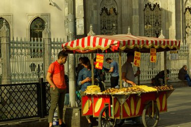 İstanbul, Türkiye - 26 Nisan 2019: İstanbul, Türkiye 'deki Pertevniyal Valide Sultan Camii önünde tipik mısır koçanı satıcısı. Etrafta birileri var..