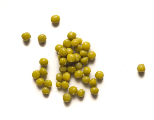 分離の白いテーブルに散在している小さなエンドウ豆の山 — ストック写真