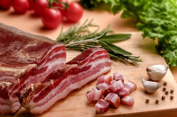 Bacon, spices and vegetables on wooden table