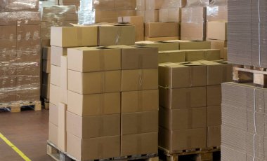 Karton paketlerle, lojistik ve dağıtım endüstrisiyle dolu bir depo.