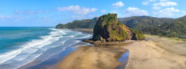 Gün doğumunda, Yeni Zelanda sahilde bir grup insan silueti. 