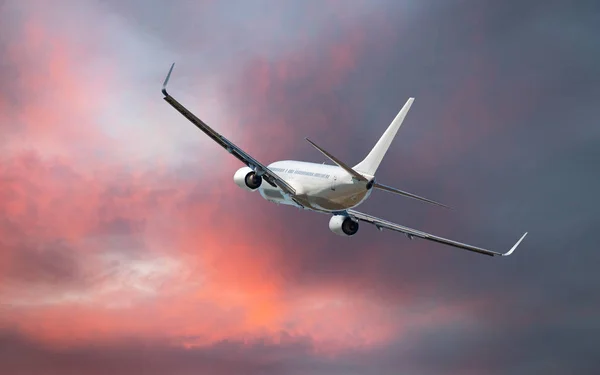 在夕阳西下的云上飞行的商业飞机 — 图库照片