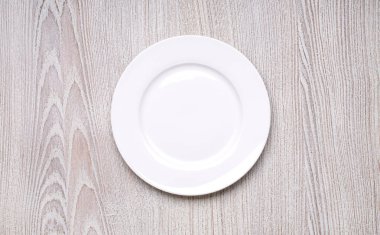 Beyaz plaka üzerinde ahşap masa arka plan üstten görünüm