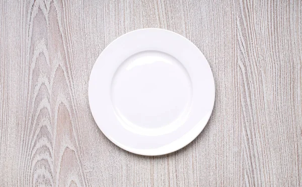 木製のテーブル背景上面の白いプレート — ストック写真