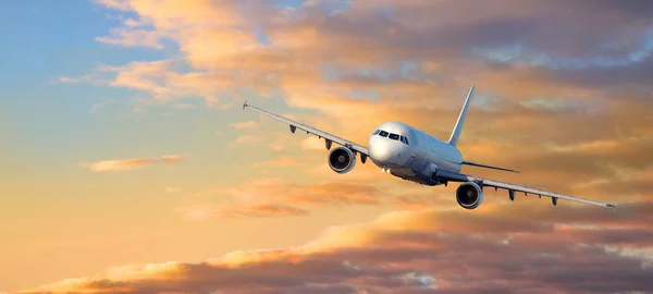 Flugzeug fliegt bei Sonnenuntergang Wolken — Stockfoto