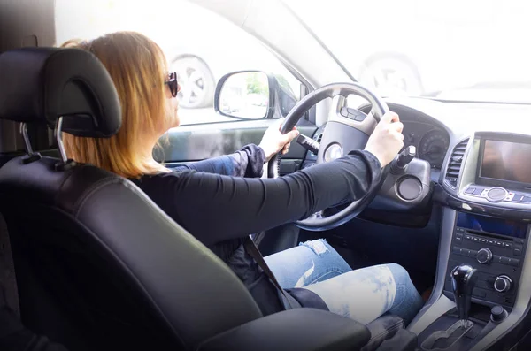 Woman in car indoor keeps wheel — Stock Photo, Image