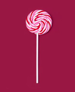 Kırmızı arka planda renkli lolipop. Düz yatıyordu. Asgari konsept