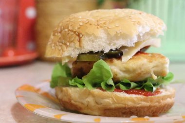 Kağıt tabağın üstünde oturan bir sandviçin yakın çekimi.