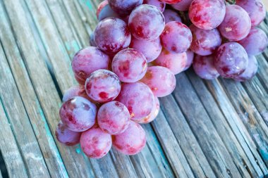 Eski ahşap masa üzerinde taze olgun mor üzüm