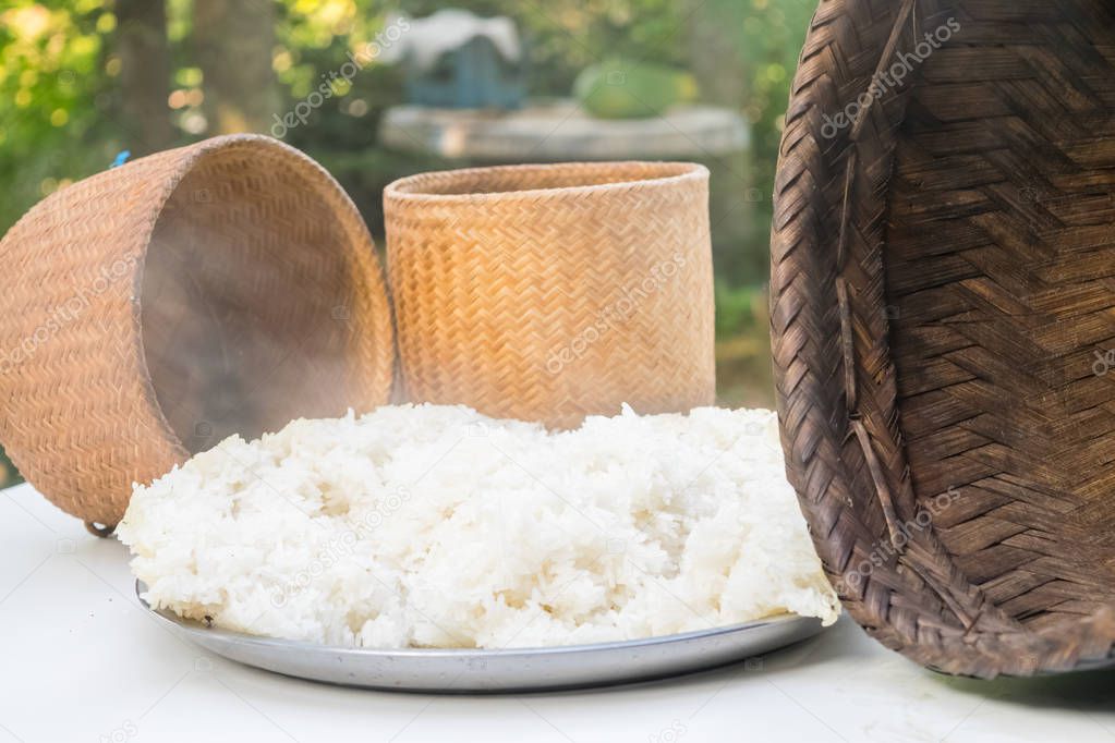 steaming sticky rice on earthen steamer , glutinous rice , northeastern of thailand food