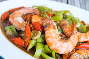 yeşil biber ile Kızarmış karides beyaz plaka üzerine ilave edin.