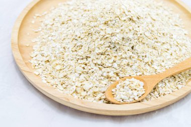 Kase ve beyaz arka planda izole ahşap kaşık yulaf gevreği. Sağlıklı gıda.