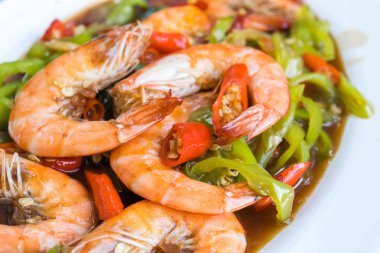 yeşil biber ile Kızarmış karides beyaz plaka üzerine ilave edin.