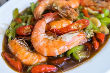 yeşil biber ile Kızarmış karides beyaz plaka üzerine ilave edin.