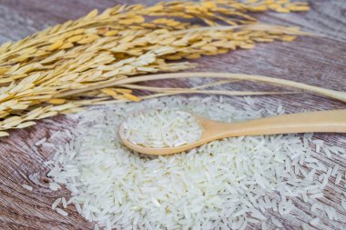 Tahta kaşık ahşap arka plan üzerinde Tayland Yasemin pirinç