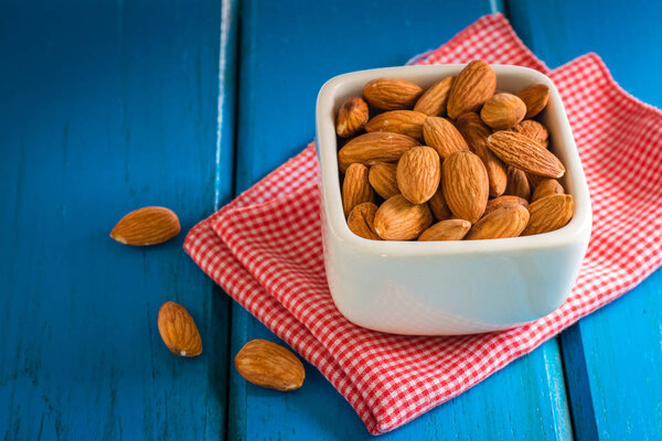 Almonds on blue wooden table