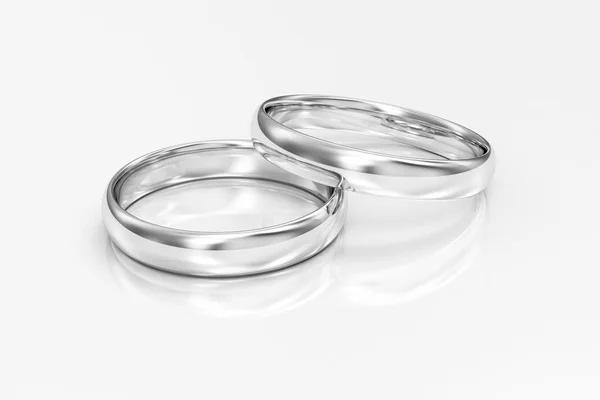 白色金结婚戒指在白色反射背景 — 图库照片