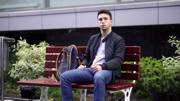 Joven Sentado Banco Calle Esperando Algo — Vídeo de stock