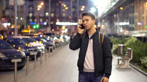 Junger Mann Telefoniert Abends Auf Der Stadtstraße Mit Bokeh Lichteffekt — Stockvideo