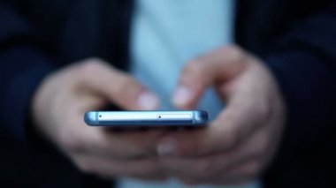 Yakın çekim görünümü, adam kullanma Smartphone şehrin sokak. 