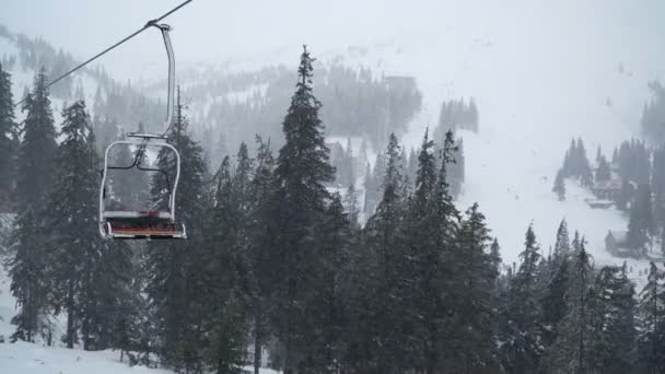 降雪と冬の山々の空のケーブルカー — ストック動画