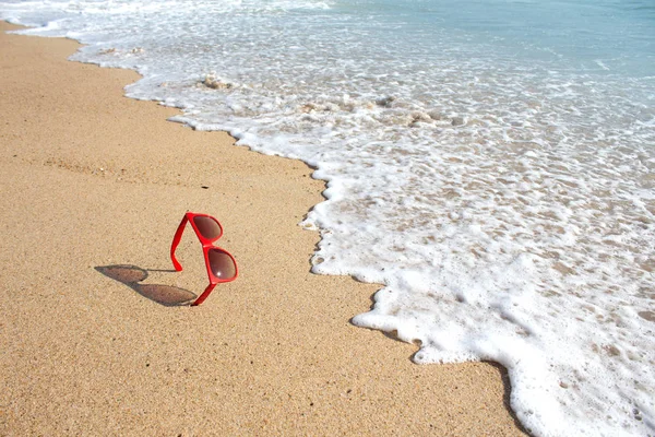 Rode zonnebril op het strand — Stockfoto