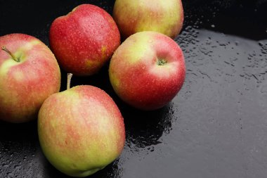 çiğ siyah bir zemin üzerine elma