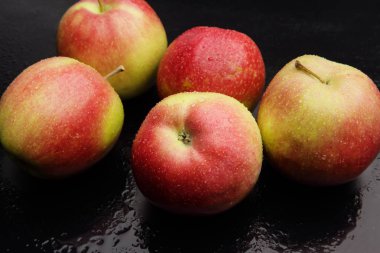 çiğ siyah bir zemin üzerine elma