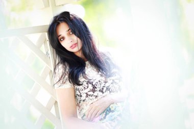 güzel genç kadın parkta, o gülümsüyor ve ağaçlar güzelliği sahiptir