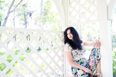 güzel genç kadın parkta, o gülümsüyor ve ağaçlar güzelliği sahiptir