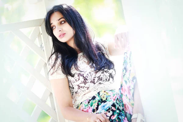 güzel genç kadın parkta, o gülümsüyor ve ağaçlar güzelliği sahiptir