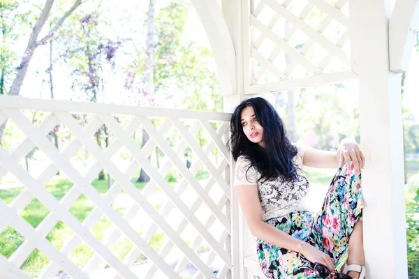 güzel genç kadın parkta, o gülümsüyor ve ağaçlar güzelliği sahiptir