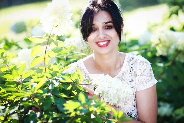 güzel genç kadın parkta, o gülümsüyor ve ağaçlar güzelliği sahiptir