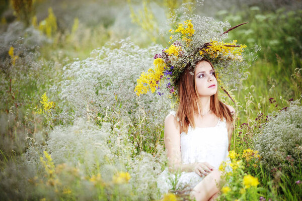 A girl in a wreath of field flowers