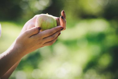 Genç bir kadının elinde bir elma