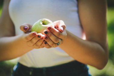 Genç bir kadının elinde bir elma