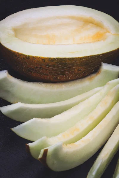 sliced melon slices on a black background