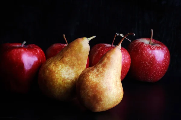 tasty juicy apples and pears on a black background