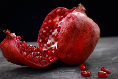 Nar karanlık bir arka plan üzerinde sulu olgun adet