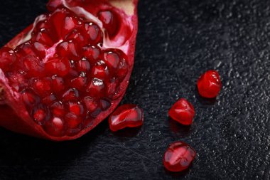 Nar karanlık bir arka plan üzerinde sulu olgun adet