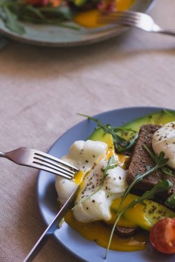 avokado, haşlanmış yumurta, roka ve domates sandviç