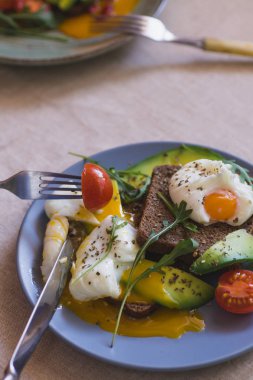 avokado, haşlanmış yumurta, roka ve domates sandviç