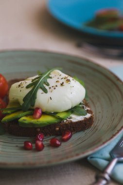 avokado, haşlanmış yumurta, roka ve domates sandviç
