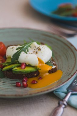 avokado, haşlanmış yumurta, roka ve domates sandviç