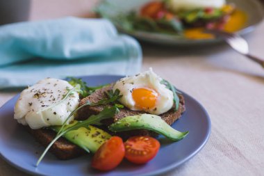 avokado, haşlanmış yumurta, roka ve domates sandviç