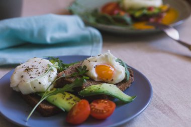 avokado, haşlanmış yumurta, roka ve domates sandviç