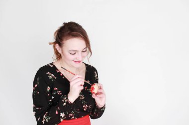 kadın beyaz bir arka plan üzerinde boya ile renkli Paskalya yumurtası boyalar