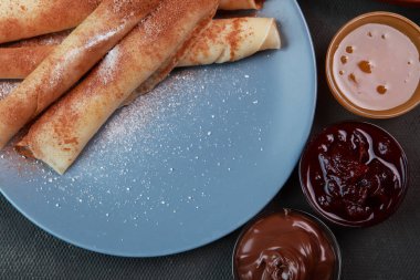 Krep ile çilek, reçel, bal ve çikolata, toz şeker ve tarçın ile serpilir